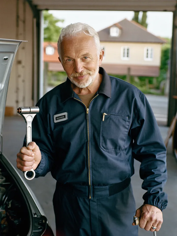 Raymond, présentateur du Garage de Raymond, devant une voiture capot ouvert